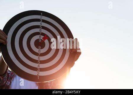 Man hand holding a target with darts hitting the center. Concept of business target. Stock Photo