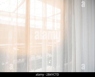 The bedroom in the city in the morning sunshine through the white curtains, giving a feeling of happiness, freshness, and warmth. Stock Photo