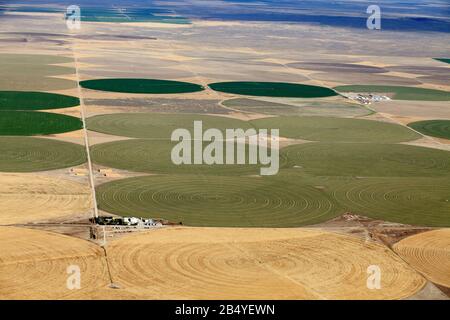 An aerial view of the crop circles created by many agricultural center pivot sprinklers used to irrigate farm land in the fertile farm fields of Idaho Stock Photo