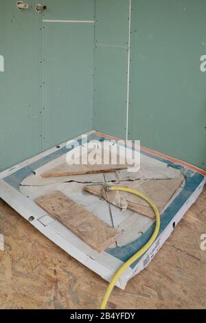 a still packed shower tray lies on the floor of a construction site Stock Photo