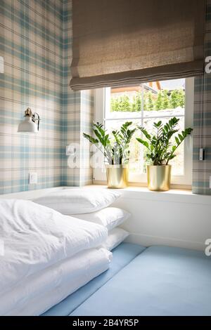 light blue bedroom with brown blinds and checkered wallpaper Stock Photo