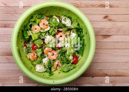 Fresh Salad with prawns, mozzarella, avocado, lettuce, tomato, oil and sesame. Stock Photo