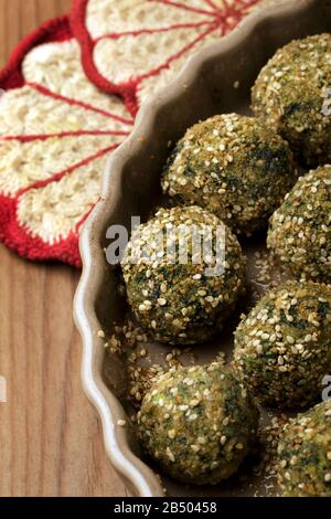 Patties of cottage cheese (ricotta) and spinach cooked in oven with breadcrumbs and sesame. Stock Photo