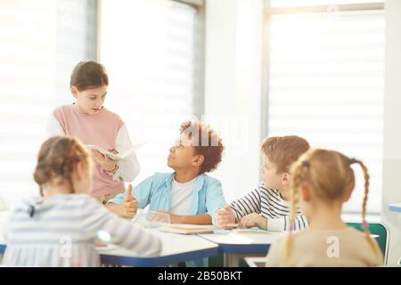 Horizontal shot of five active middle school students working together on interesting lesson task, copy space Stock Photo