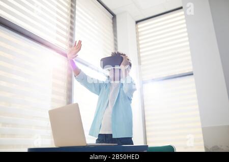 Horizontal shot of unrecognizable African American boy experiencing augmented reality using VR headset, copy space Stock Photo