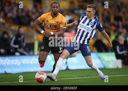 Wolverhampton Wanderers' Adama Traore (left) and Brighton and Hove Albion's Leandro Trossard battle for the ball during the Premier League match at Molineux, Wolverhampton. Stock Photo