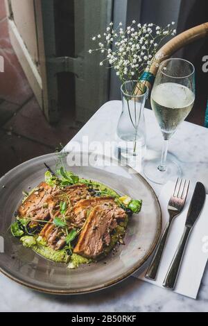 Pork Belly In Pipian Verde 14 hour slow cooked pork belly with crunchy skin, pumpkin seeds and green tomatillos salsa. Stock Photo