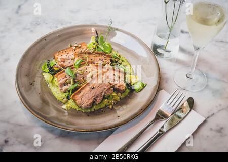 Pork Belly In Pipian Verde 14 hour slow cooked pork belly with crunchy skin, pumpkin seeds and green tomatillos salsa. Stock Photo
