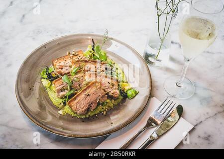 Pork Belly In Pipian Verde 14 hour slow cooked pork belly with crunchy skin, pumpkin seeds and green tomatillos salsa. Stock Photo