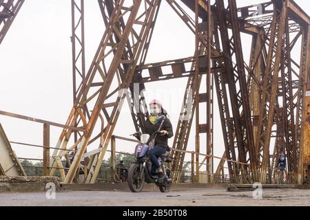 Hanoi Long Bien bridge - Woman motorist rides accross the historic Long Bien bridge in Hanoi, Vietnam, Southeast Asia. Stock Photo