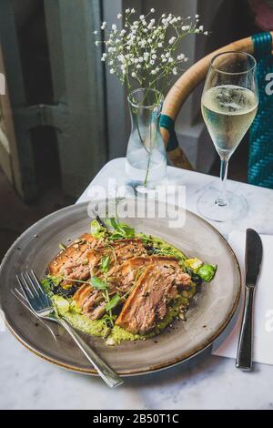 Pork Belly In Pipian Verde 14 hour slow cooked pork belly with crunchy skin, pumpkin seeds and green tomatillos salsa. Stock Photo