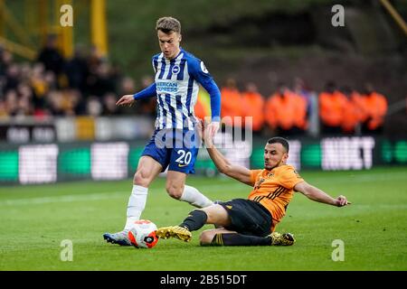 Wolverhampton, UK. Wolverhampton, UK. 7th March 2020English Premier League, Wolverhampton Wanderers versus Brighton and Hove Albion; Romain Sa&#xef;ss of Wolverhampton Wanderers gets contact to clear the ball from the feet of Solly March of Brighton &amp; Hove Albion Credit: Action Plus Sports Images/Alamy Live News Credit: Action Plus Sports Images/Alamy Live News Stock Photo