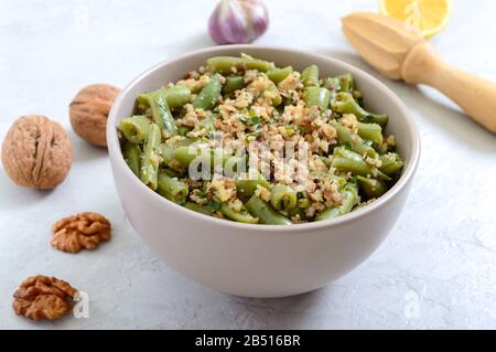 Salad with green beans and spicy walnut sauce in a bowl. Vegetarian, vegan menu Stock Photo