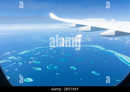 Top view of Maldive islands from airplane window with airplane's wing Stock Photo