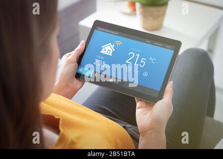 Woman using smart home application on tablet. Smart home system concept Stock Photo