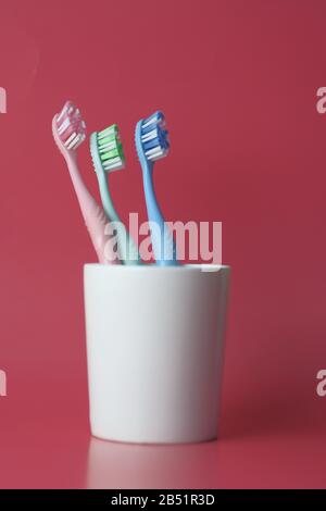 toothbrush in a glass on a red background Stock Photo