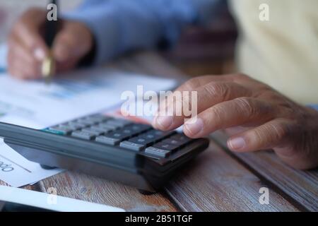 Close up of senior man using calculator  Stock Photo