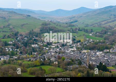 The town of Ambleside and its St Mary's Church with a stone spire built in the 1850s seen from Loughrigg Fell, Lake District, Cumbria, England. Stock Photo