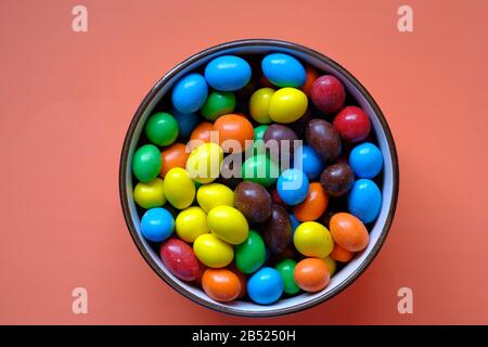 colorful chocolate candy in a bowl on range background Stock Photo
