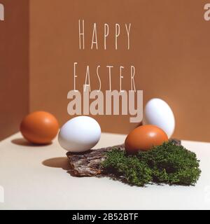 Four multi-colored eggs and natural materials moss and wood. Easter concept. Stock Photo