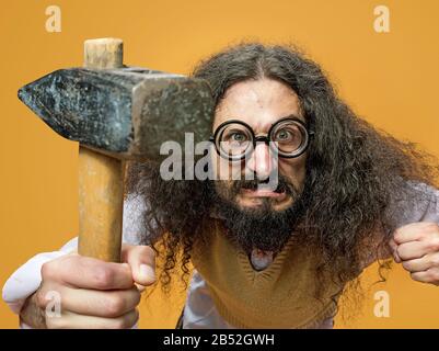 Closeup portrait of a nerd holding a hammer Stock Photo