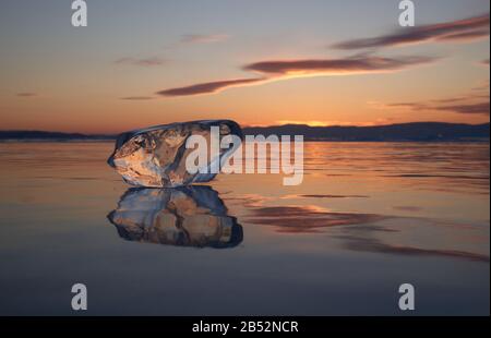 A piece of ice is reflected in Baikal at sunset Stock Photo