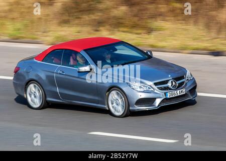 2015 SILVER BLUE Mercedes-Benz E220 AMG Line Prem Bluete; UK Vehicular traffic, road transport, modern vehicles, saloon cars, convertible, convertibles, soft-top, open topped, roadster, cabriolets, drop-topsvehicle driving, roads & motors, motoring on the M6 motorway highway Stock Photo