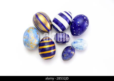 Happy Easter. Many easter eggs trendy colored classic blue, white and golden on white. Minimal style, top view, flatlay, copy space. Stock Photo
