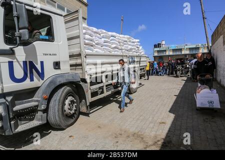 Palestinians receive their monthly food aid at a United Nations distribution center (UNRWA) in the southern Gaza Strip town of Rafah, on March 7, 2020 Stock Photo