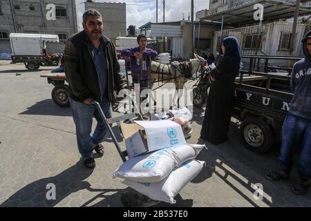 Palestinians receive their monthly food aid at a United Nations distribution center (UNRWA) in the southern Gaza Strip town of Rafah, on March 7, 2020 Stock Photo