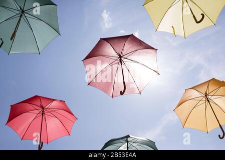 Multicolored umbrellas against a sunny blue sky. Stock Photo