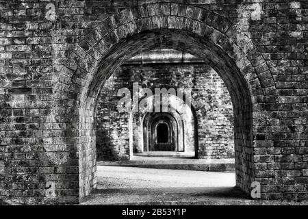 Throught the diminishing creepy perspective of contrast arches in old historic aqueduct made of bricks in Japanese city Kyoto. Stock Photo