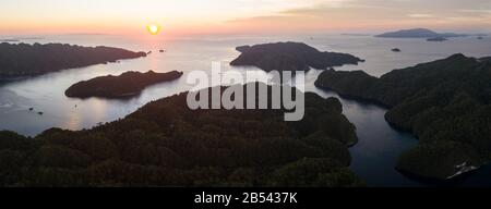 Sunset illuminates the sky over Alyui Bay, Waigeo, Raja Ampat. This beautiful body of water harbors extraordinary marine biodiversity. Stock Photo