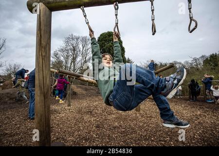 Active boys climbing on the RHS Back to Nature Garden outdoor activity area at RHS Wisley co-designed by The Duchess of Cambridge, Surrey, England, UK Stock Photo