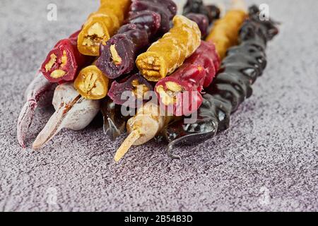 Caucasian whole churchkhela from grapes juice and walnuts on gray background close-up still life. Churchkhela is ancient Georgian and Azerbaijani national sweetness Stock Photo