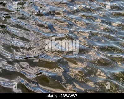 Close up view of moving surface of the water in slow motion splashing waves of ocean. Stock Photo