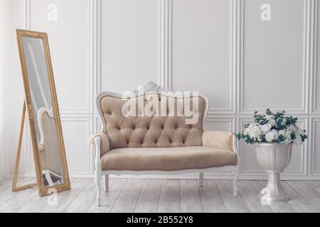 Flowers in Vase next to White Sofa. Minimalism. Stock Photo