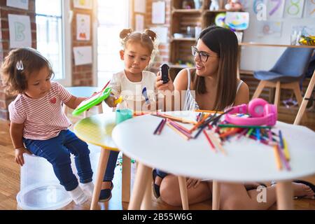 Young beautiful teacher and toddlers playing at kindergarten Stock Photo