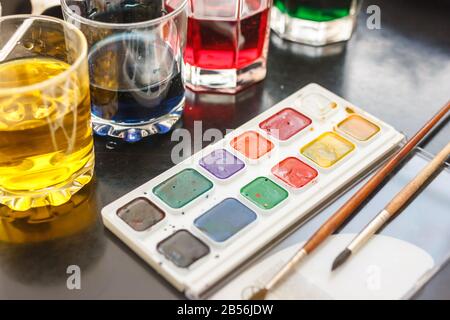 glasses with multicolored coloring water ant paints. close-up. Easter preparations. Stock Photo