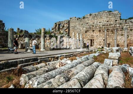 The ruins of the Palaestra where an ancient Greek wrestling school stood at Perge in Turkey. In the background is the exterior wall of the Roman Baths Stock Photo