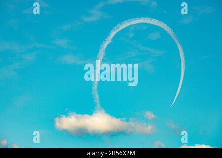 Jet looping through clouds at Air Show Stock Photo