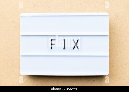 White lightbox with word fix on wood background Stock Photo