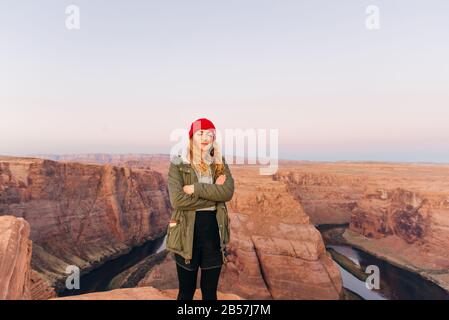 girl on Horseshoe Bend in Glen Canyon National Recreation Area in early dawn Stock Photo