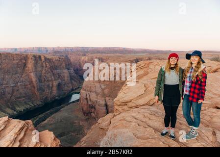 girls on Horseshoe Bend in Glen Canyon National Recreation Area in early dawn Stock Photo