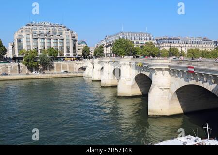 Pedestrians crossing Pont Neuf from the right bank of the Seine. This bridge connects the Ile de la Cite to both banks. Stock Photo