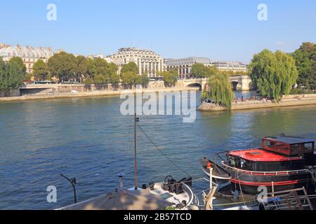 Barges and houseboats near Pont Neuf and the Ile de la Cite on the left bank of the river Seine. Many of these boats are popular tourists rentals. Stock Photo