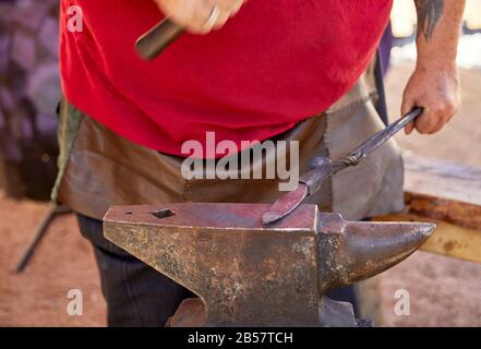 Blacksmith making a steel knife using an anvil and hammer. Stock Photo