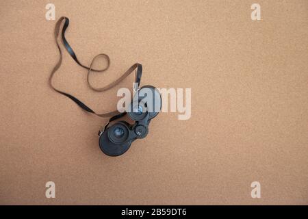 Binoculars on brown background with copy space Stock Photo