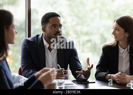 Diverse multiracial colleagues discuss ideas at briefing Stock Photo