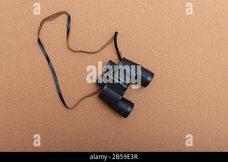 Binoculars on brown background with copy space Stock Photo